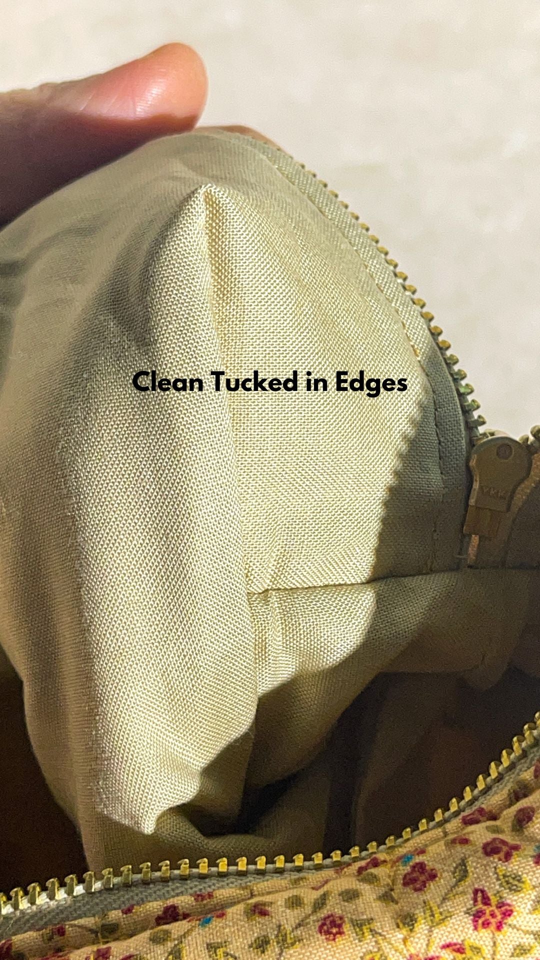 closeup view of the handmade sustainable quilted mustard yellow cotton boxy pouch, highlighting the gold zipper detail.