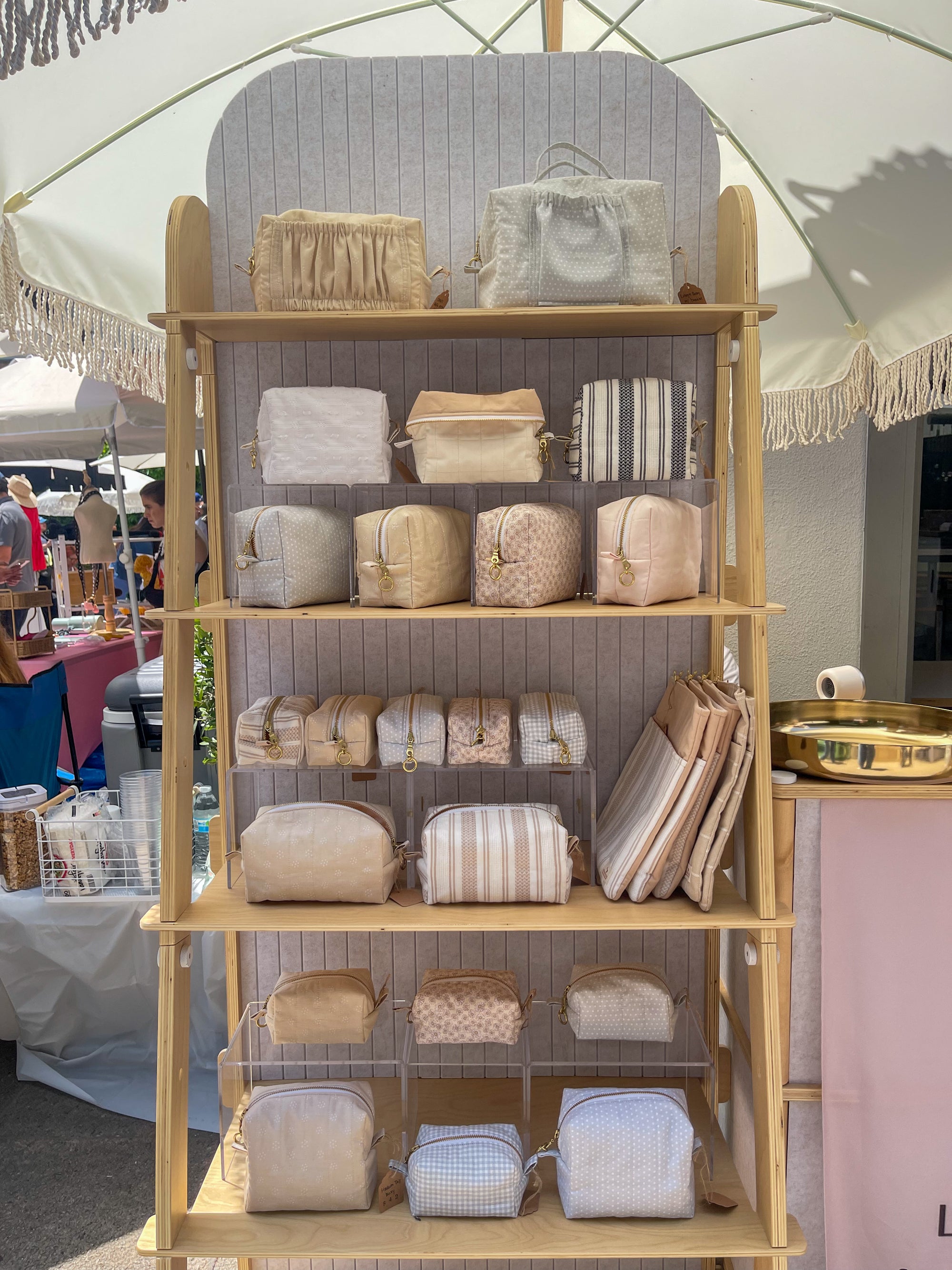 Display of Lovinglog handmade sustainable makeup pouch bags on a wooden shelf with a neutral background