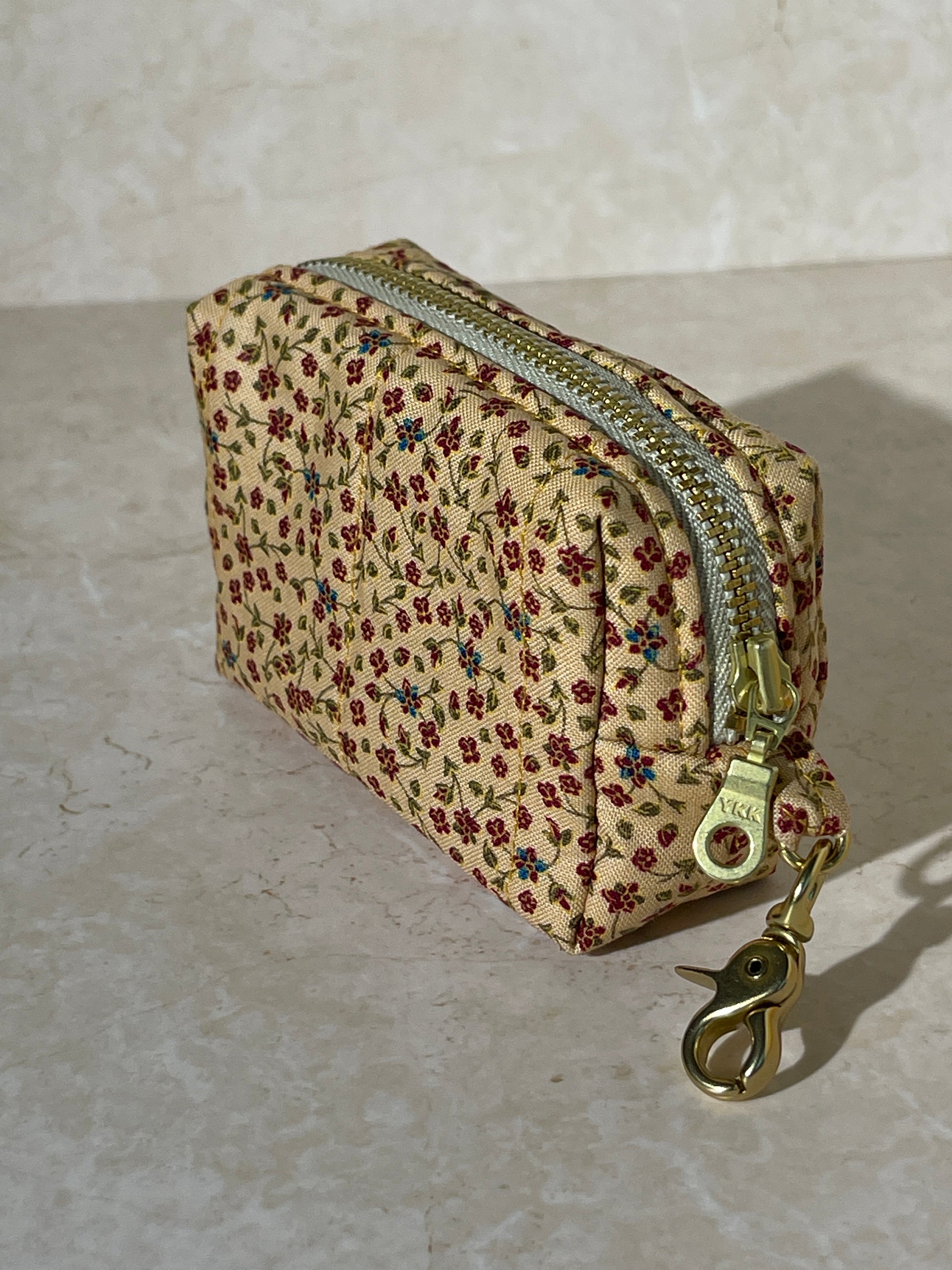Lovinglog Handmade Sustainable Floral-patterned keychain pouch with a zipper on a light marble background