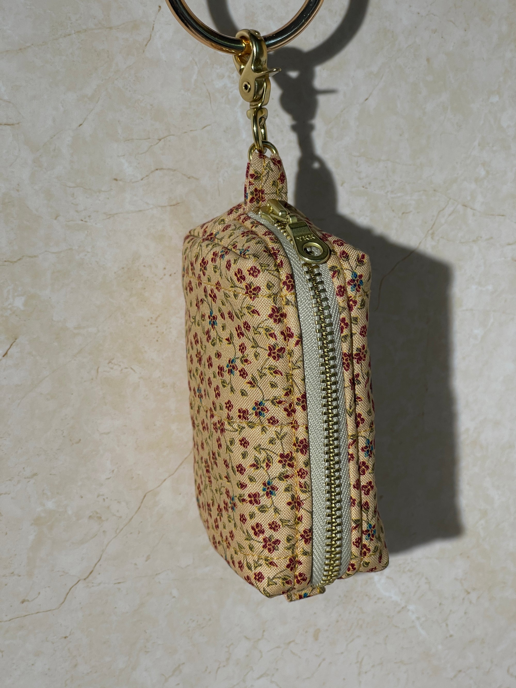 Lovinglog Handmade Sustainable Floral-patterned keychain pouch with a zipper on a light marble background