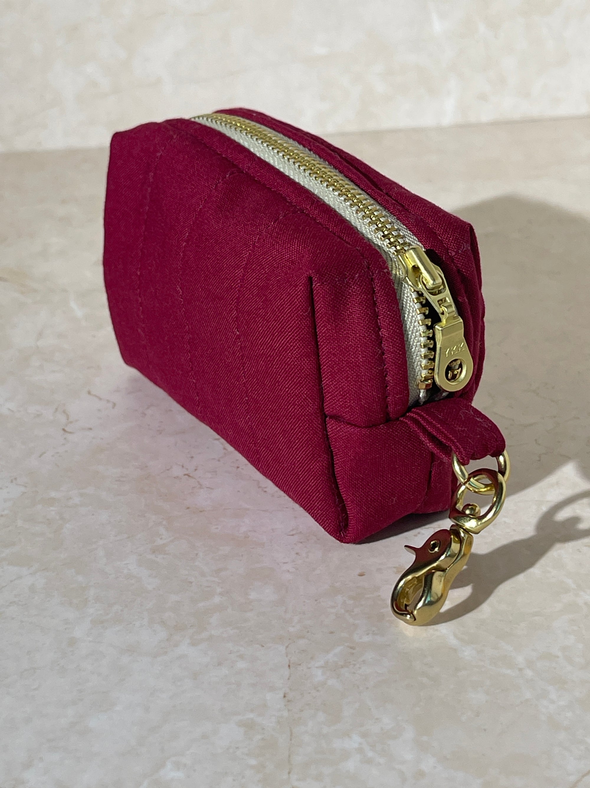 Lovinglog Handmade Sustainable red keychain pouch with a zipper on a light marble background