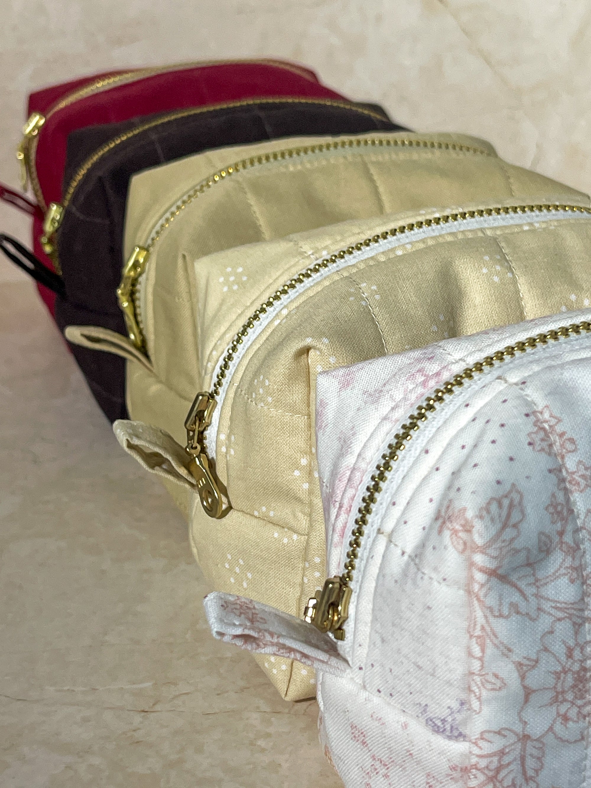 Set of Lovinglog sustainable small handmade makeup pouch bags with zippers on a beige surface